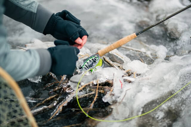 photo of a person adjusting their fly fishing equipment